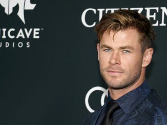 Chris Hemsworth in a black suit and shirt, showing no sign of having been inflated