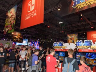People playing games under a Nintendo Switch banner at E3