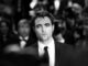 Black and white pic of Robert Pattinson with a crowd out of focus. Batman