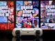 A playstation 5 controller, infront of the covers for each GTA game. GTA trilogy bug