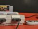 a snes system with two controllers on a red table. SNES Maxi.
