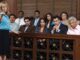 Portrait of a female advocate pointing with jurors sitting together in the witness stand at court house. 12 Angry Men remake