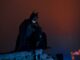 batman, perched on top of a building. barman wanted