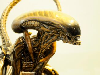 a toy xenomorph on a yellow back ground. Alien reboot