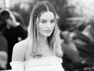 Margot Robbie. Black and white. From chest upwrds. Looks quite glum. Barbie movie.