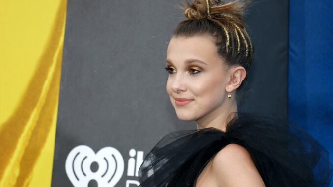 millie bobby brown in black dress from shoulders up. Enola Holmes 2
