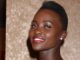 Lupita Nyong'o head shot against gold background. A quiet place: day one