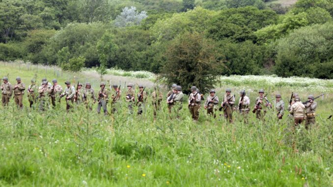 A line of american soldiers in a field. not in band of brothers