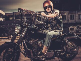 Tattooed biker and his bobber style motorcycle on a city streets. Easy Rider reboot