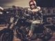 Tattooed biker and his bobber style motorcycle on a city streets. Easy Rider reboot