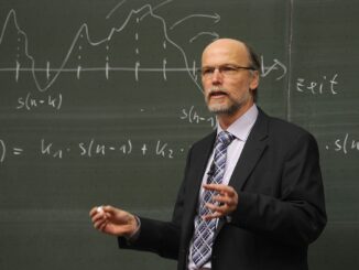 a bald professor in front of a blackboard explaining something . lady ghostbusters