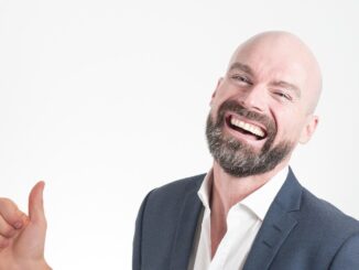 Bald man with beard in a suit giving thumbs up. new superhero.