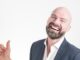 Bald man with beard in a suit giving thumbs up. new superhero.