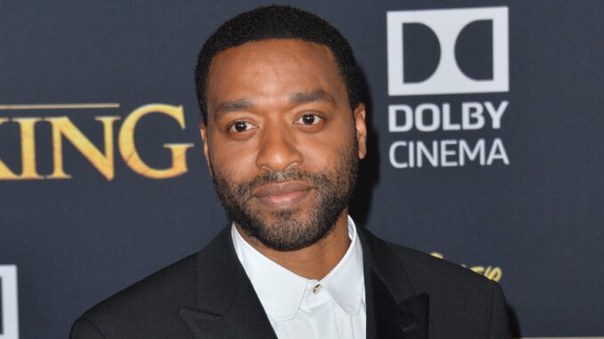 A picture of chiwetel Ejiofor in a dark suit, shoulders up. Venom 3