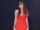 angelia jolie in red dress against black background