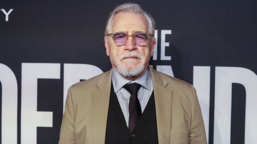 Brian cox from waist up in suit and sweater and glasses. Succession spin-off