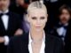 Charlize Theron from shoulders up with crowd behind her