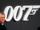 Daniel Craig stood in front of a giant 007 sign