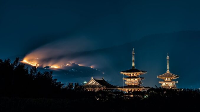 A temple in Japan at night which looks like it could come from the new season of shogun although there might be some electrical lights but you know Japan, they're always pushing ahead with technology